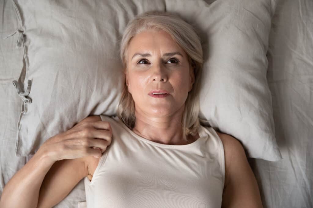 woman lying awake in bed thjinking
